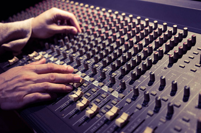 在演播室坐的微笑的年輕酣然的生產(chǎn)商